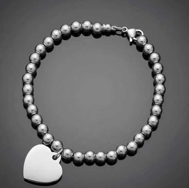 Pulsera bolitas de ac. Inox. 4mm plateado c/cierre langosta con dije de acero inoxidable