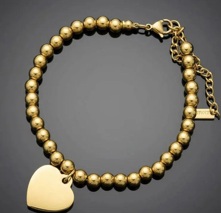 Pulsera bolitas de ac. Inox. 4mm dorado c/dije corazon pequeno c/cierre langosta Personalizable